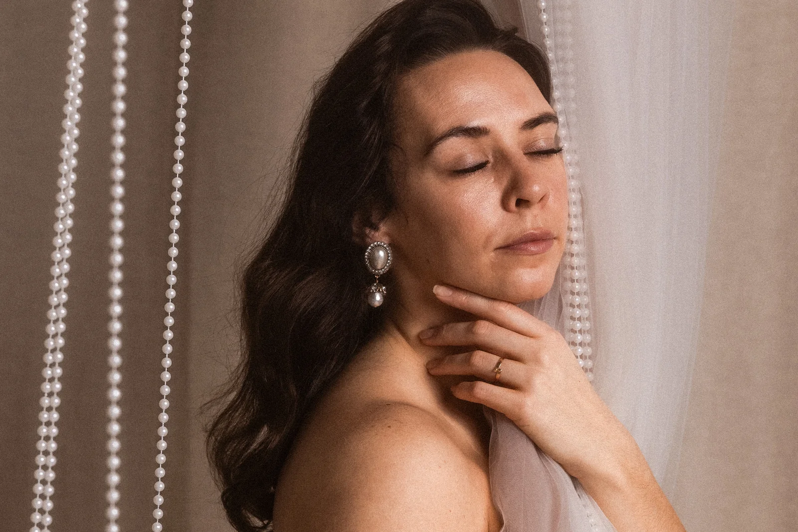 Minimalistyczny portret - kobieta z zamkniętymi oczami. Zbliżenie na twarz, w tle korale i jasne tło.