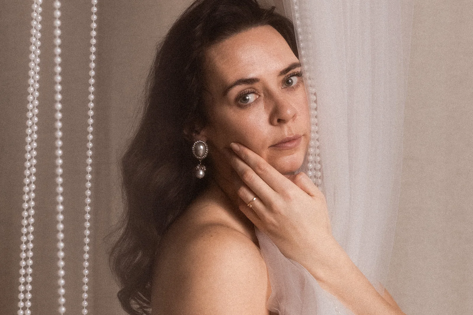 Delikatny portret kobiety w stylu fine art w artystycznej pozie - ręka dotyka delikatnie twarz modelki