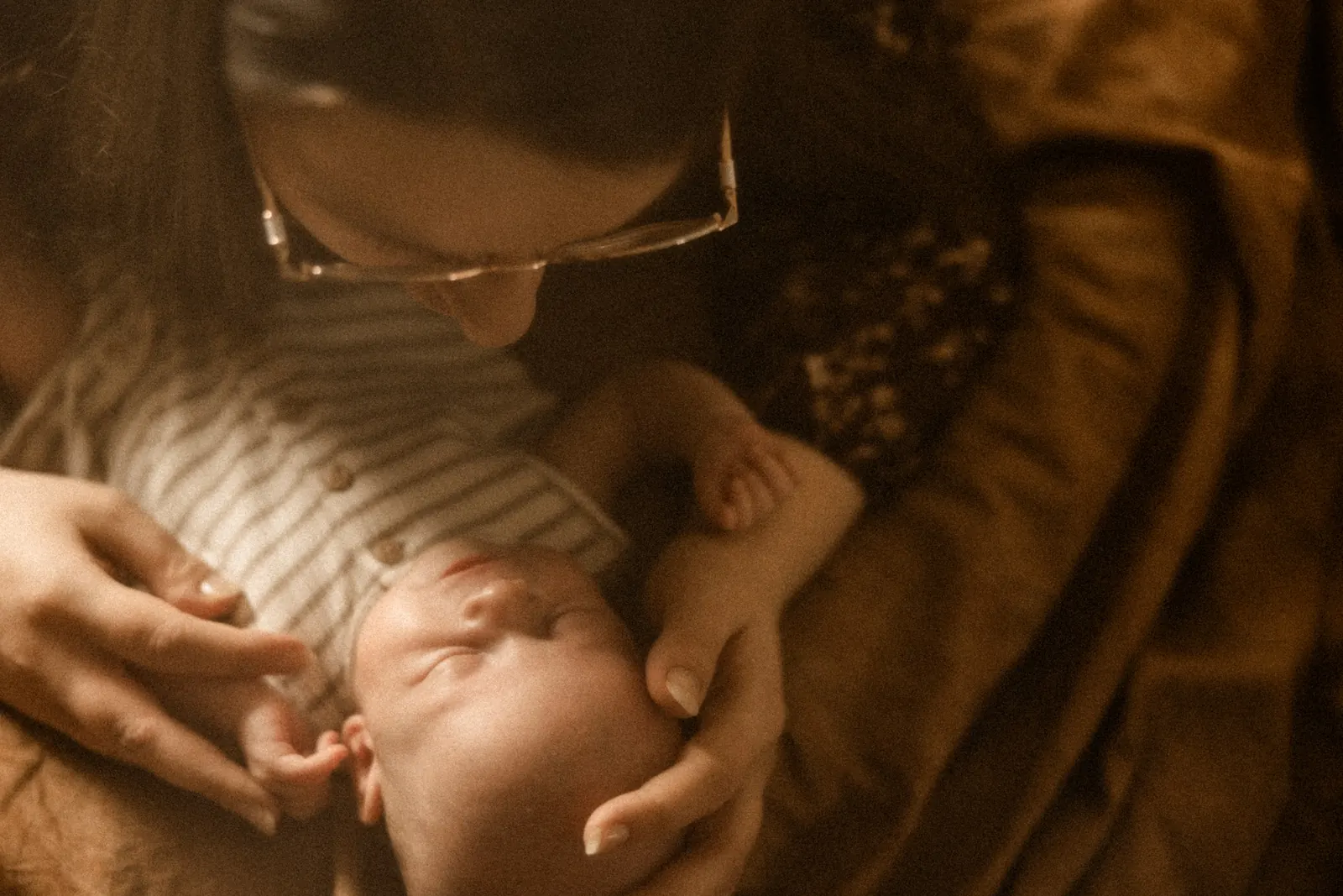 Mama przytula dziecko podczas domowej sesji noworodkowej w Poznaniu