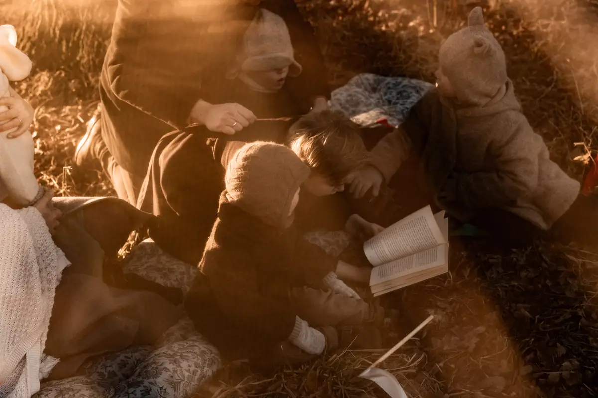 Pełna emocji fotografia rodziców z dziećmi na łące podczas rodzinnej sesji zdjęciowej w plenerze