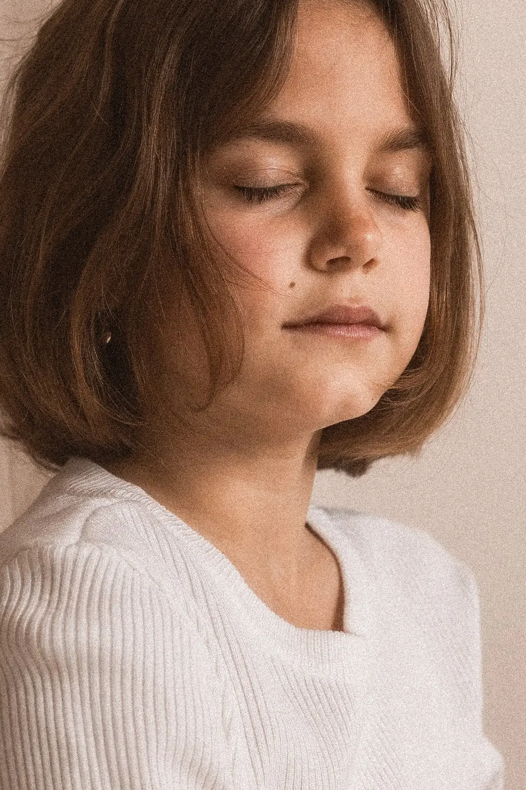 Portret dziewczynki w delikatnej pozie podczas sesji zdjęciowej w studiu