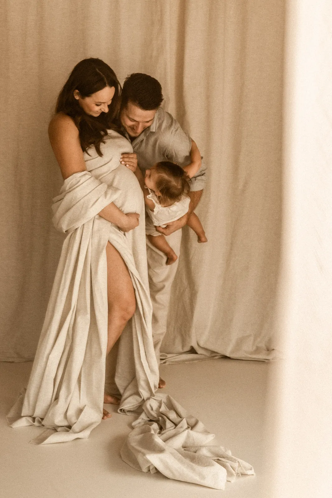 Radosna zabawa taty z dzieckiem podczas rodzinnej sesji ciążowej