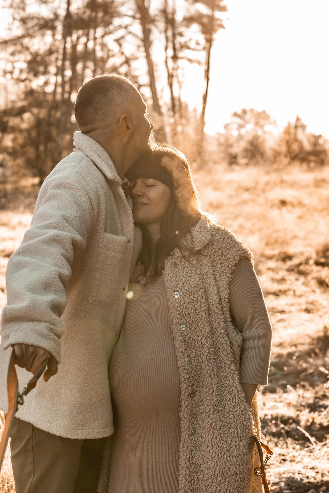 Jesienna sesja ciążowa dla par na tle drzew w Poznaniu