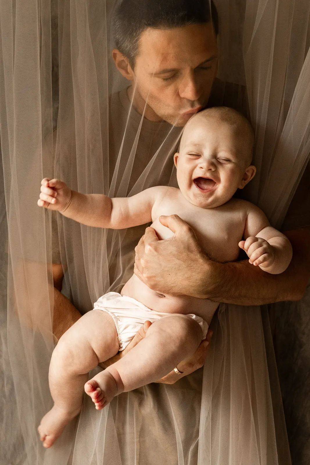 Tata trzymający niemowlaka na rękach podczas sesji zdjęciowej