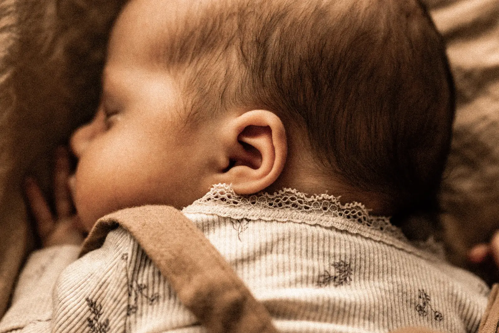 Spokojny sen niemowlaka śpiącego na kocyku podczas naturalnej sesji zdjęciowej w domu