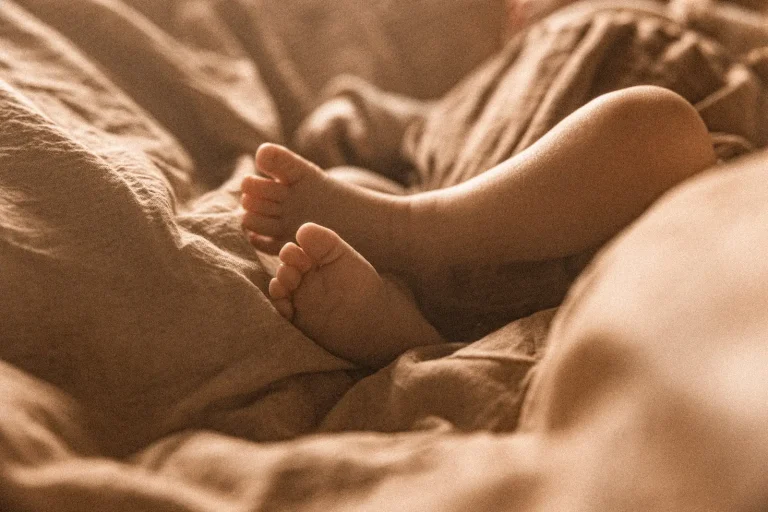 Zbliżenie na nóżki dziecka podczas domowej sesji noworodkowej