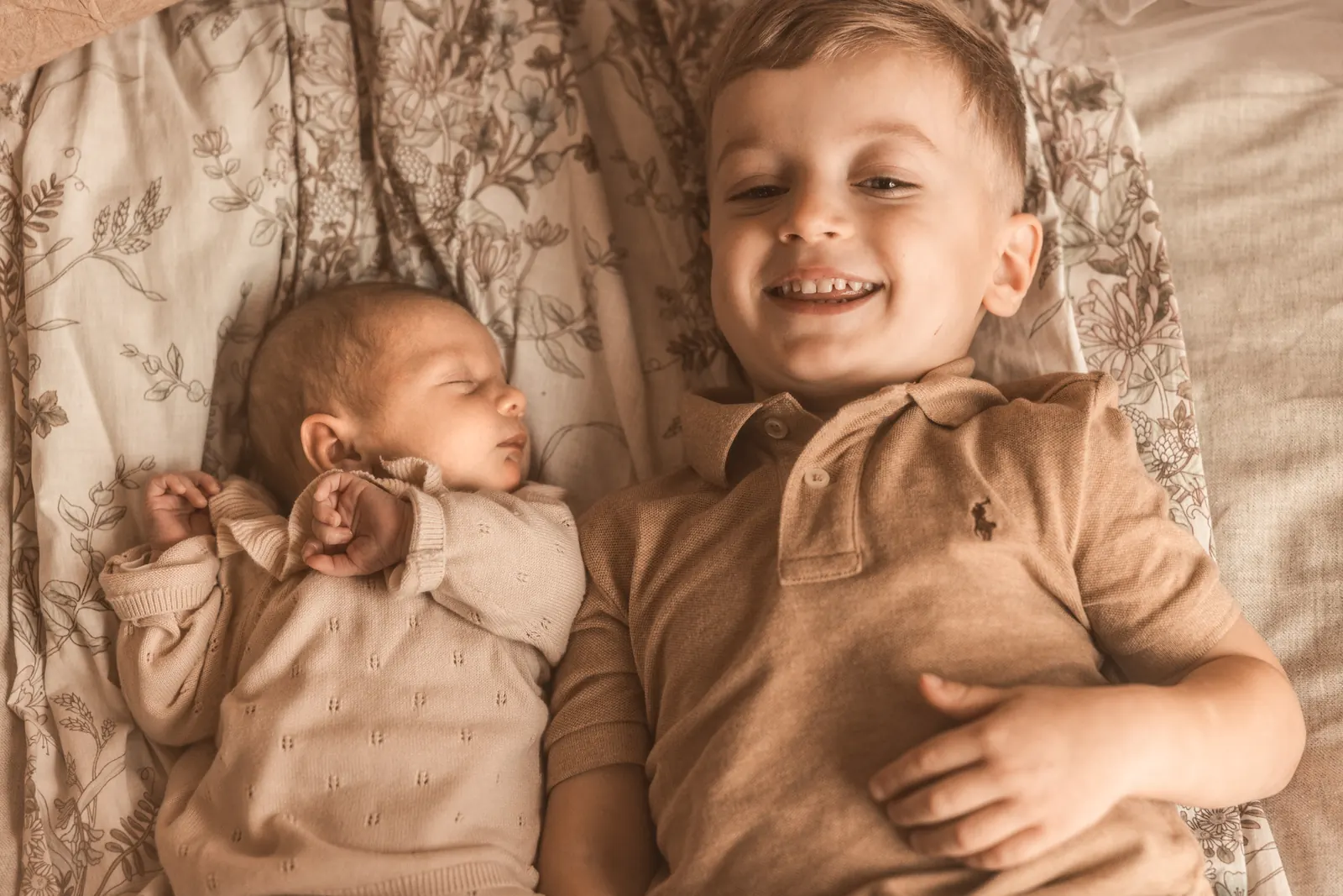 Rodzinne zdjęcie braciszka z noworodkiem w jasnej kolorystyce w stylu boho