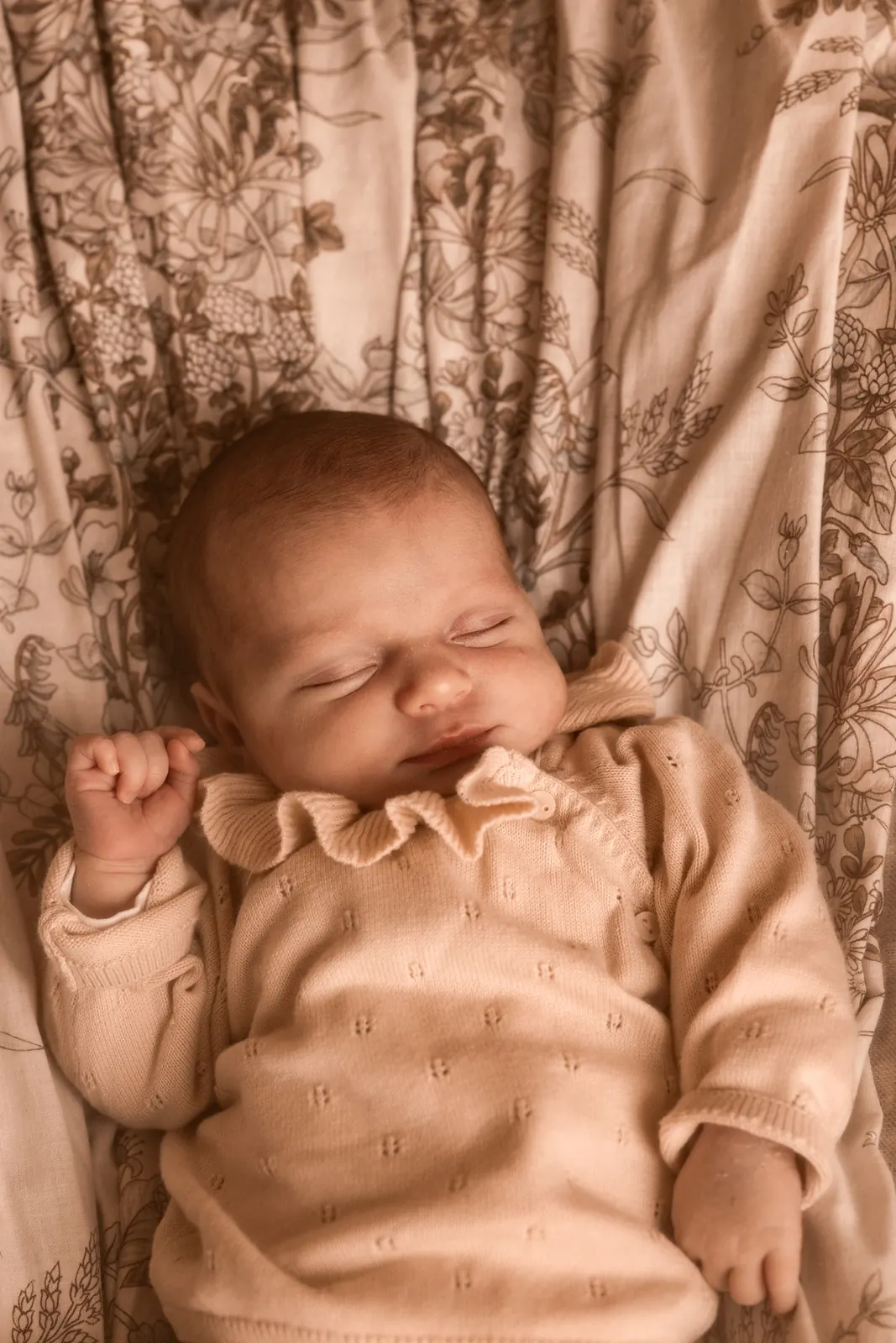 Minimalistyczny portret noworodka śpiącego z zamkniętymi oczami, w tle jasne tło