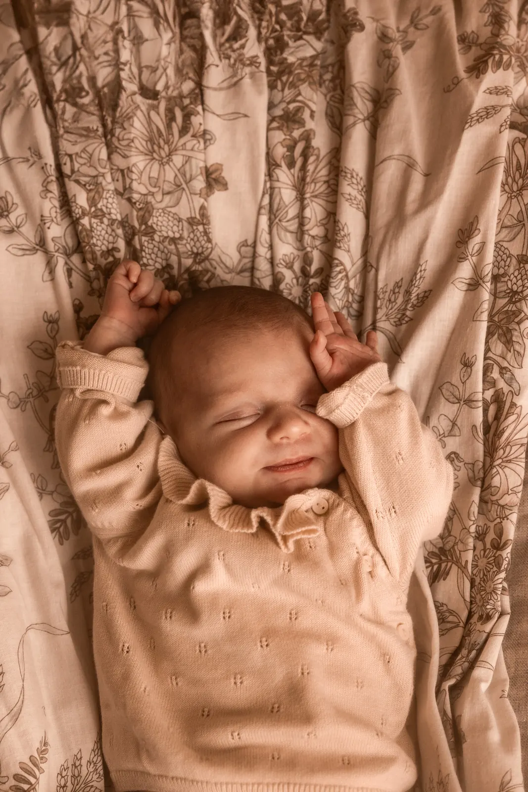 Noworodek śpiący na jasnym kocu podczas sesji noworodkowej w studio w Poznaniu