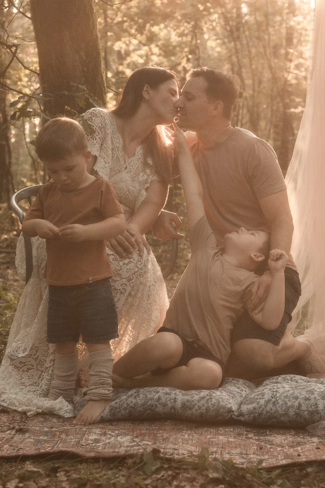 Czuła scena rodziców z dziećmi w leśnej scenerii plenerowej, kolorystyka w stylu boho