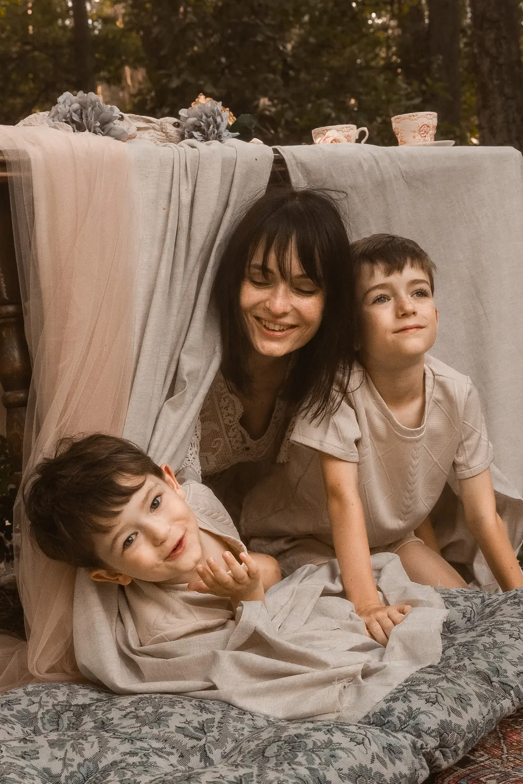 Rodzinna sesja pełna śmiechu i zabawy mamy z dziećmi w Poznaniu. Mama ubrana w koronkową suknie. Letnia sesja zdjęciowa.