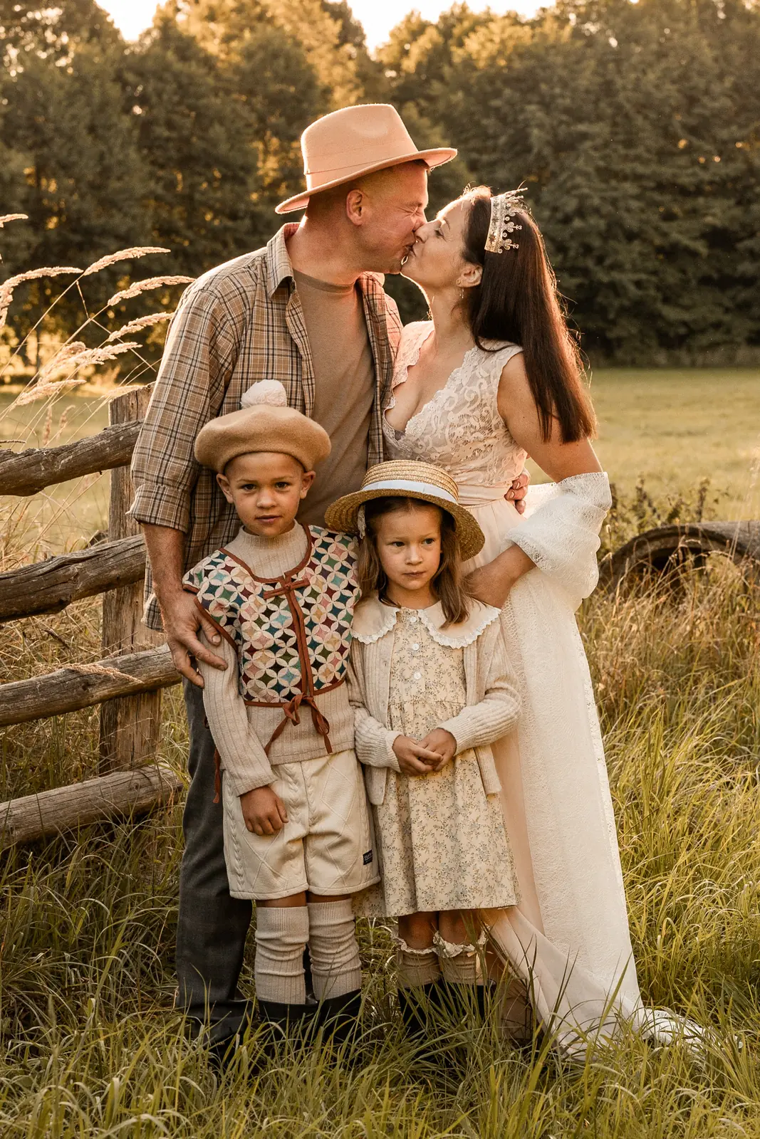 Rodzice podczas pocałunku, obok dzieci stoją przytuleni. W tle magiczna sceneria plenerowa w trakcie sesji zdjęciowej w Poznaniu.