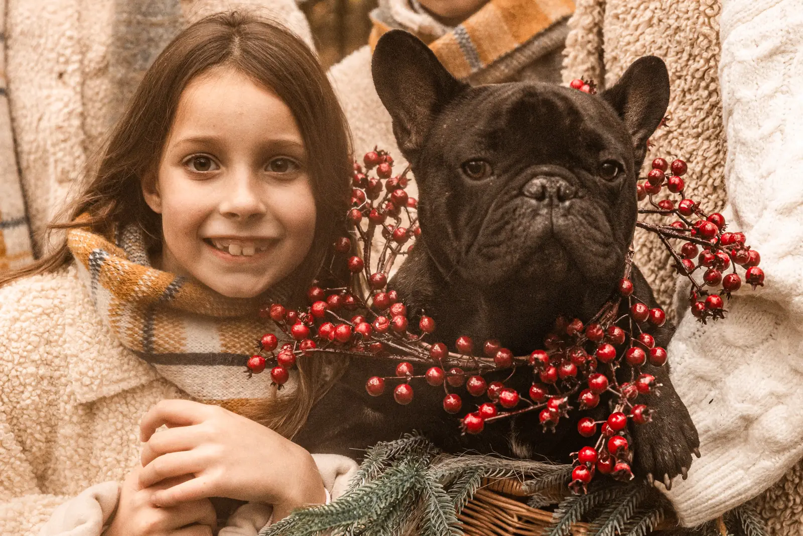 Zimowy portret dziecka i psa. Wesołe zdjęcie z ozdobami świątecznymi.