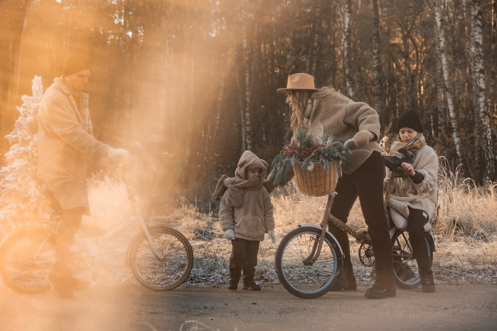 Rodzice z dziećmi na rowerach podczas plenerowej sesji zimowej. Rowery ubrane w świąteczne ozdoby.