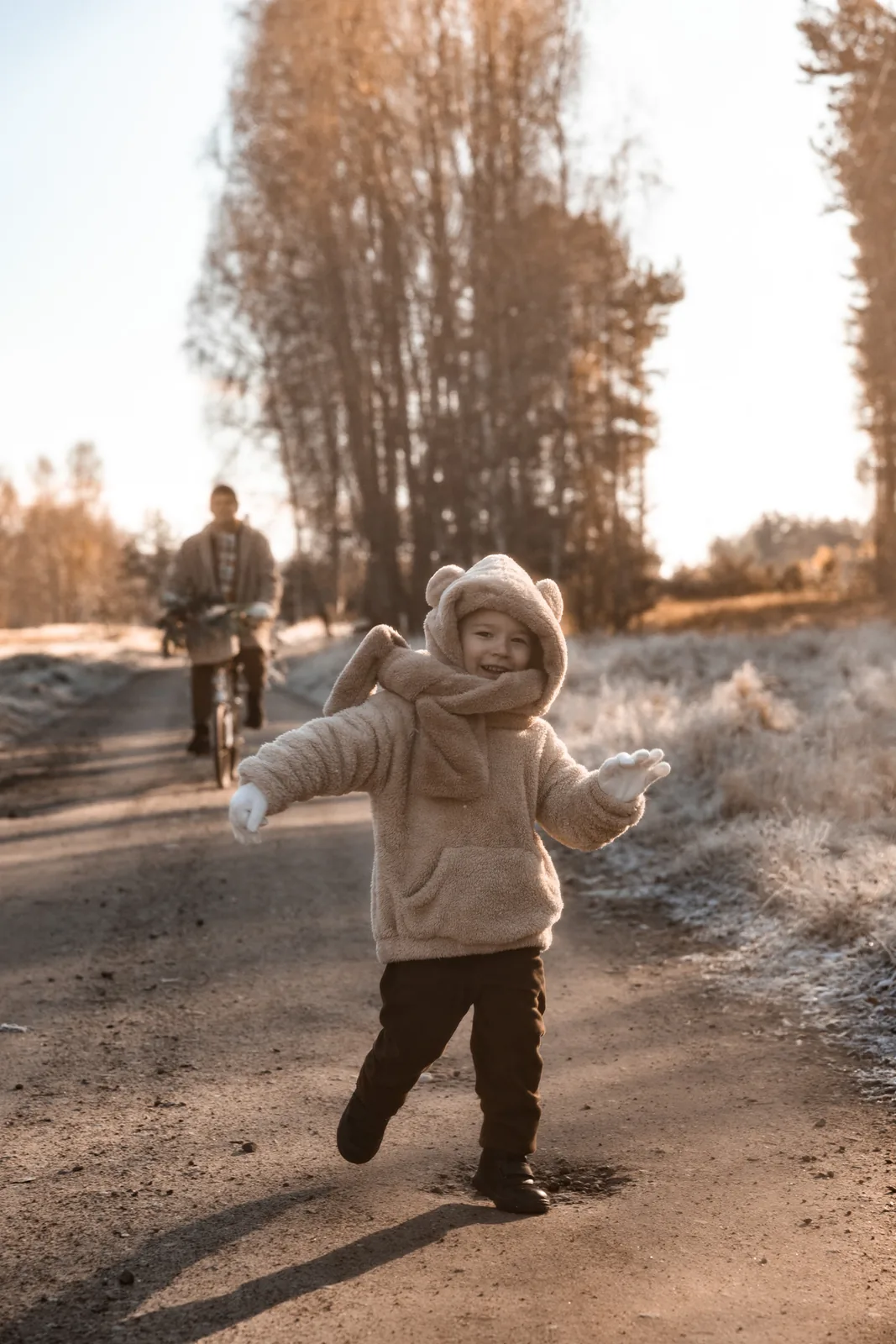 Minimalistyczny kadr taty i dziecka podczas plenerowej sesji świątecznej. W tle łąka i las.