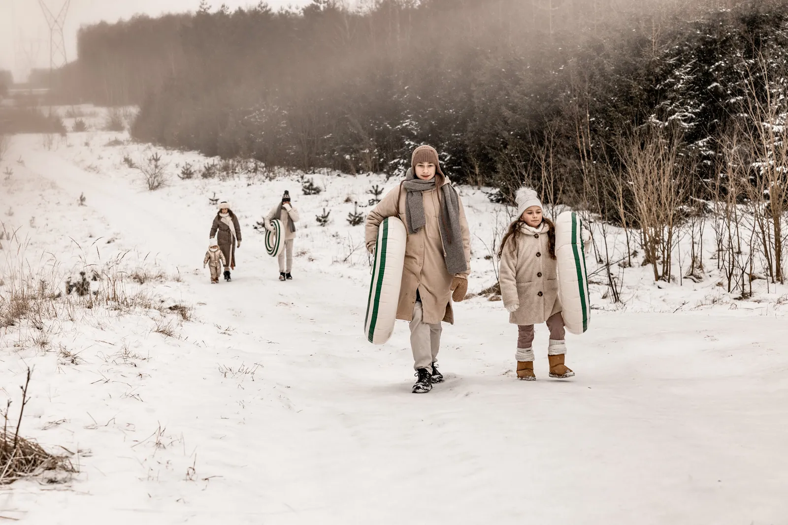 Koniec zabawy - rodzina wraca z śnieżnej górki podczas naturalnej sesji zdjęciowej w plenerze
