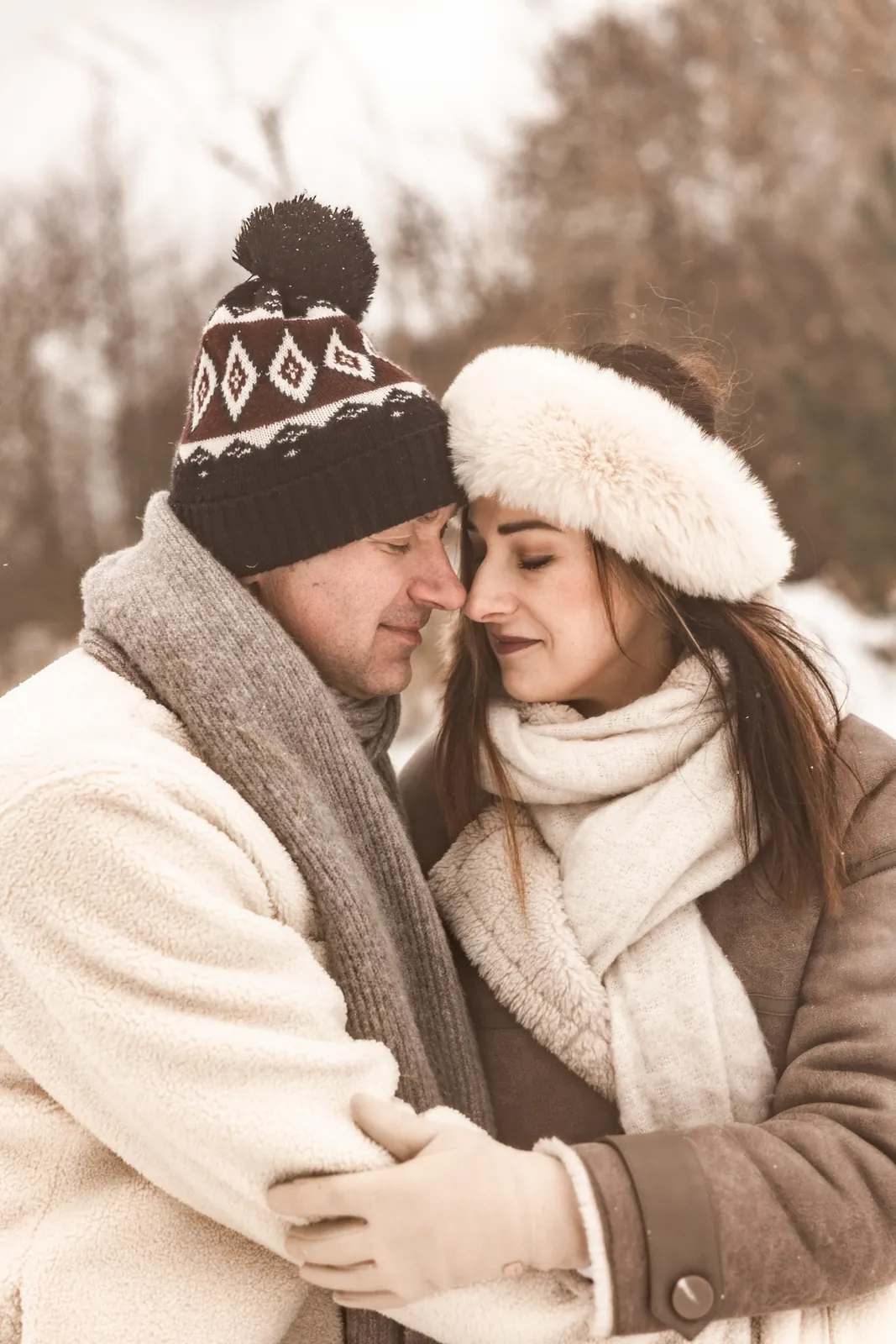 Naturalny portret rodziców w śnieżno-zimowej scenerii, w tle las