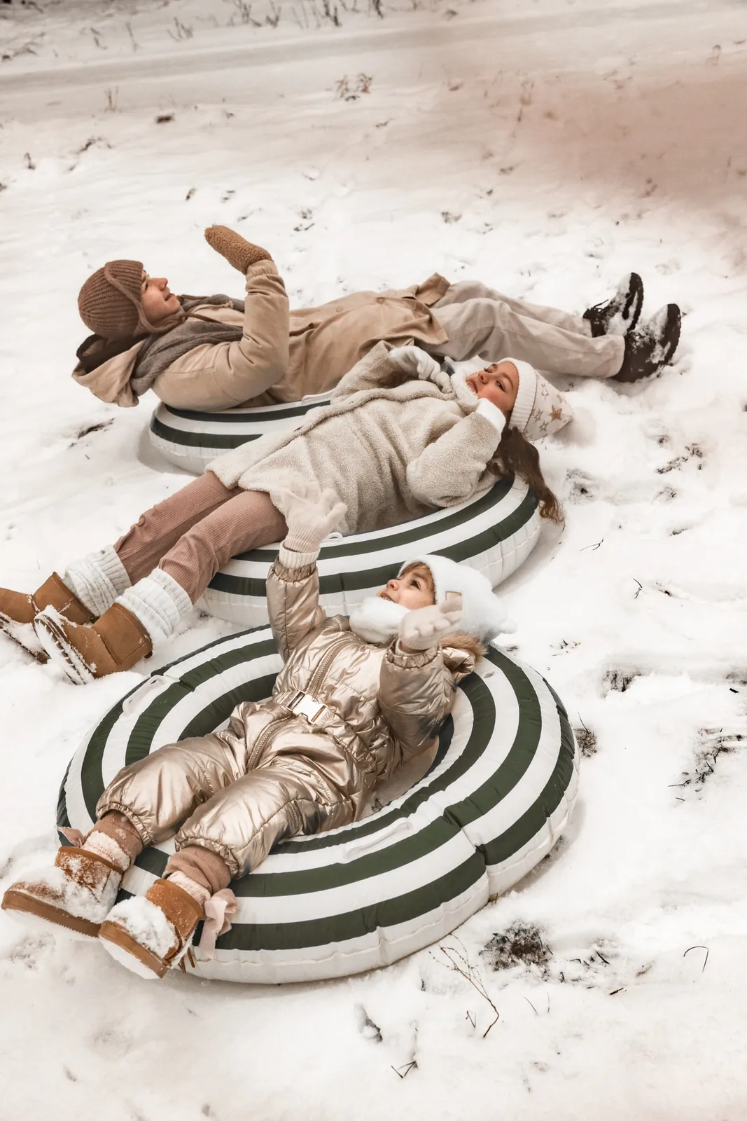 Uśmiech dzieci podczas zimowej sesji rodzinnej w śniegu, rodzeństwo na śniegu w trakcie zabawy